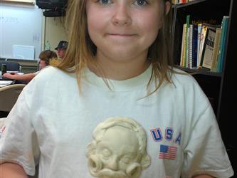 Student with clay art project